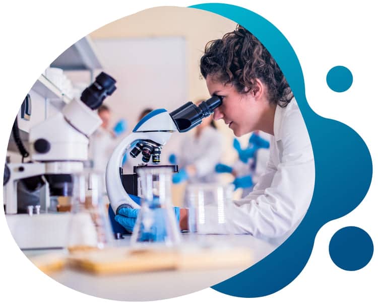 A young researcher looking into a microscope as she studies samples and collects findings for her clinical trial