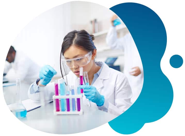 A young medical researcher testing clinical trial samples as some of her colleagues also work in the background