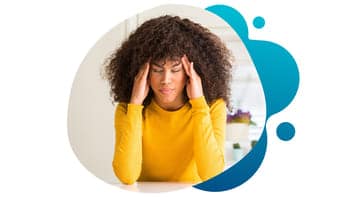 Migraines – Conquest Research clinical trial.jpg A young woman with strong migraines holding her temples as she squeezes her eyes in pain