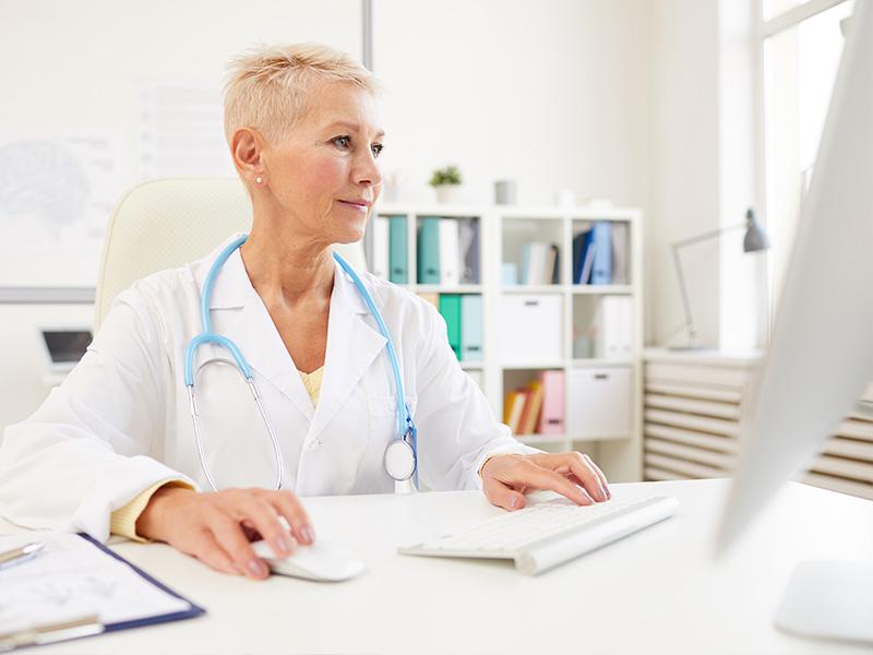 A doctor is working on the computer.