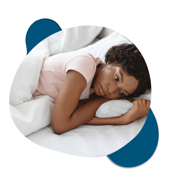 Tired woman lying on bed struggling with fatigue